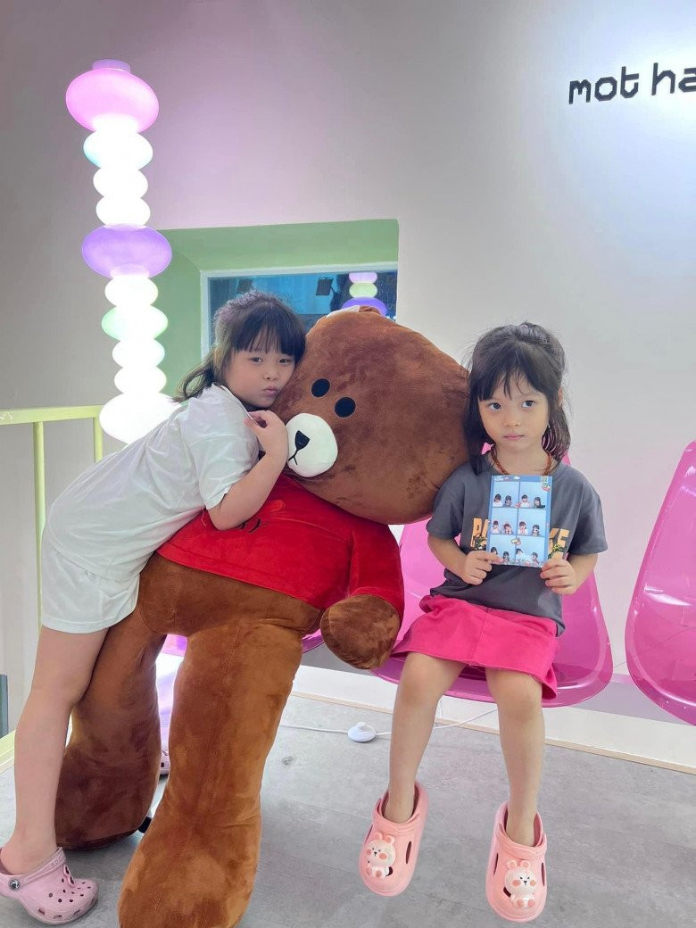 Ba bạn nữ trẻ tạo dáng vui vẻ trong một buồng chụp ảnh lấy liền, với nhiều phụ kiện và khung hình sáng tạo