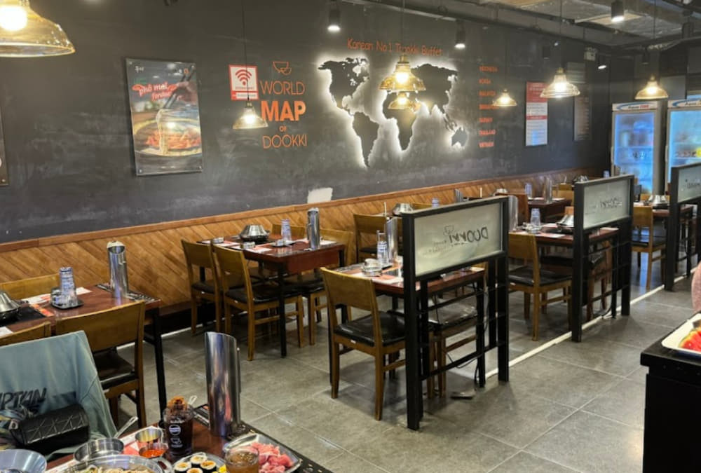 Bàn ăn gọn gàng với nồi lẩu Tokpokki và các món ăn kèm tại Dookki Buffet