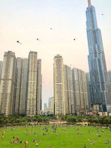 Hình ảnh gia đình thả diều trên bãi cỏ xanh mướt tại Công viên bờ sông Landmark 81 Vinhomes Central Park