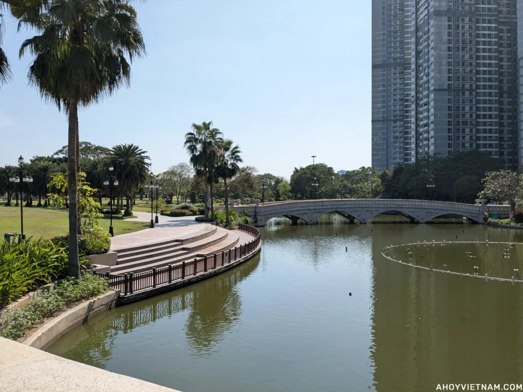 Hồ nước với cầu đá và hàng cọ tại Công viên Central Park