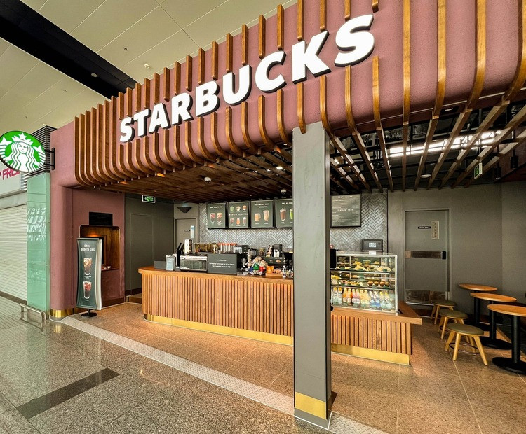 Khách hàng thư giãn tại một cửa hàng Starbucks ở Sân bay Nội Bài, điểm dừng chân lý tưởng trước giờ bay, thể hiện sự tiện lợi của chuỗi quán cà phê Starbucks