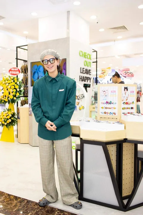 Quỳnh Anh Shyn tạo dáng bên tủ trưng bày giày Crocs tại Vincom Đồng Khởi