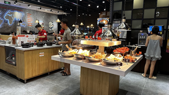Khung cảnh bên trong nhà hàng Dookki Vincom Lê Văn Việt Hồ Chí Minh với quầy buffet tokbokki đa dạng topping